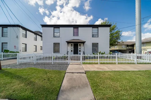 a front view of a house with a garden and plants