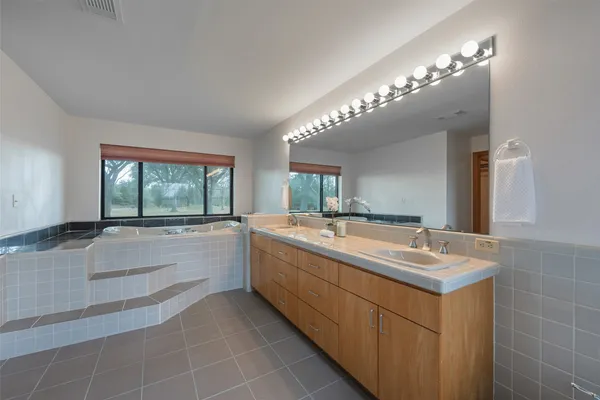 a bathroom with a sink a large mirror and a bathtub