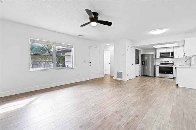 a view of empty room with wooden floor and window