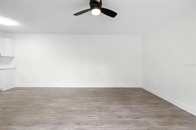 a view of a room with wooden floor and white walls