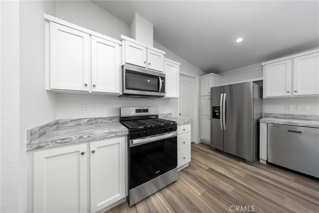 1855 East Riverside Drive, Unit 252 Ontario, CA 91761 - Photo 2 of 32 a kitchen with stainless steel appliances granite countertop a stove a refrigerator and a microwave