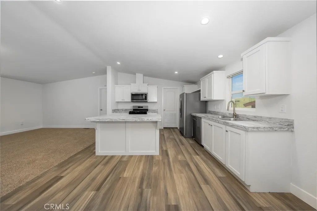 1855 East Riverside Drive, Unit 252 Ontario, CA 91761 - Photo 23 of 32 a kitchen with granite countertop a sink stove cabinets and refrigerator