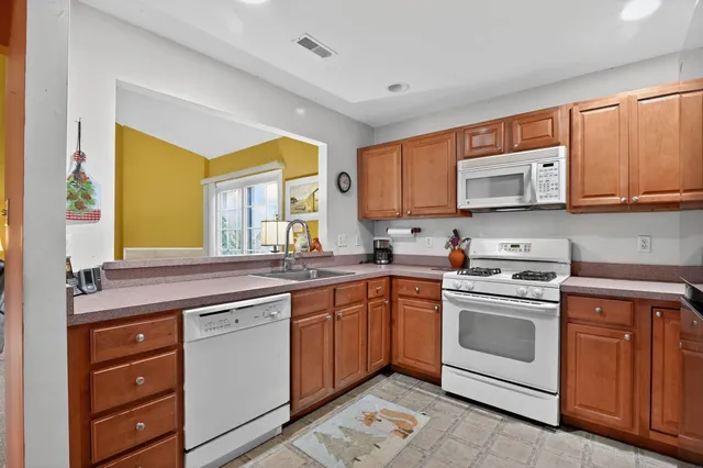 a kitchen with stainless steel appliances granite countertop a stove a sink and a microwave