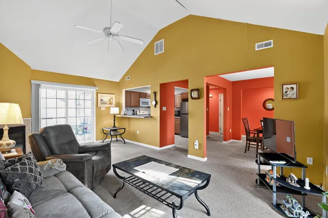 a living room with furniture a flat screen tv and a window