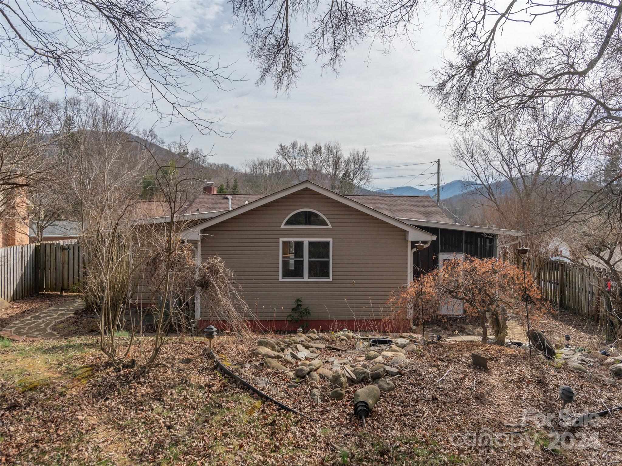 40 Wagon Road Asheville, NC 28805 - Photo 26 of 29 a backyard of a house with large trees and wooden fence