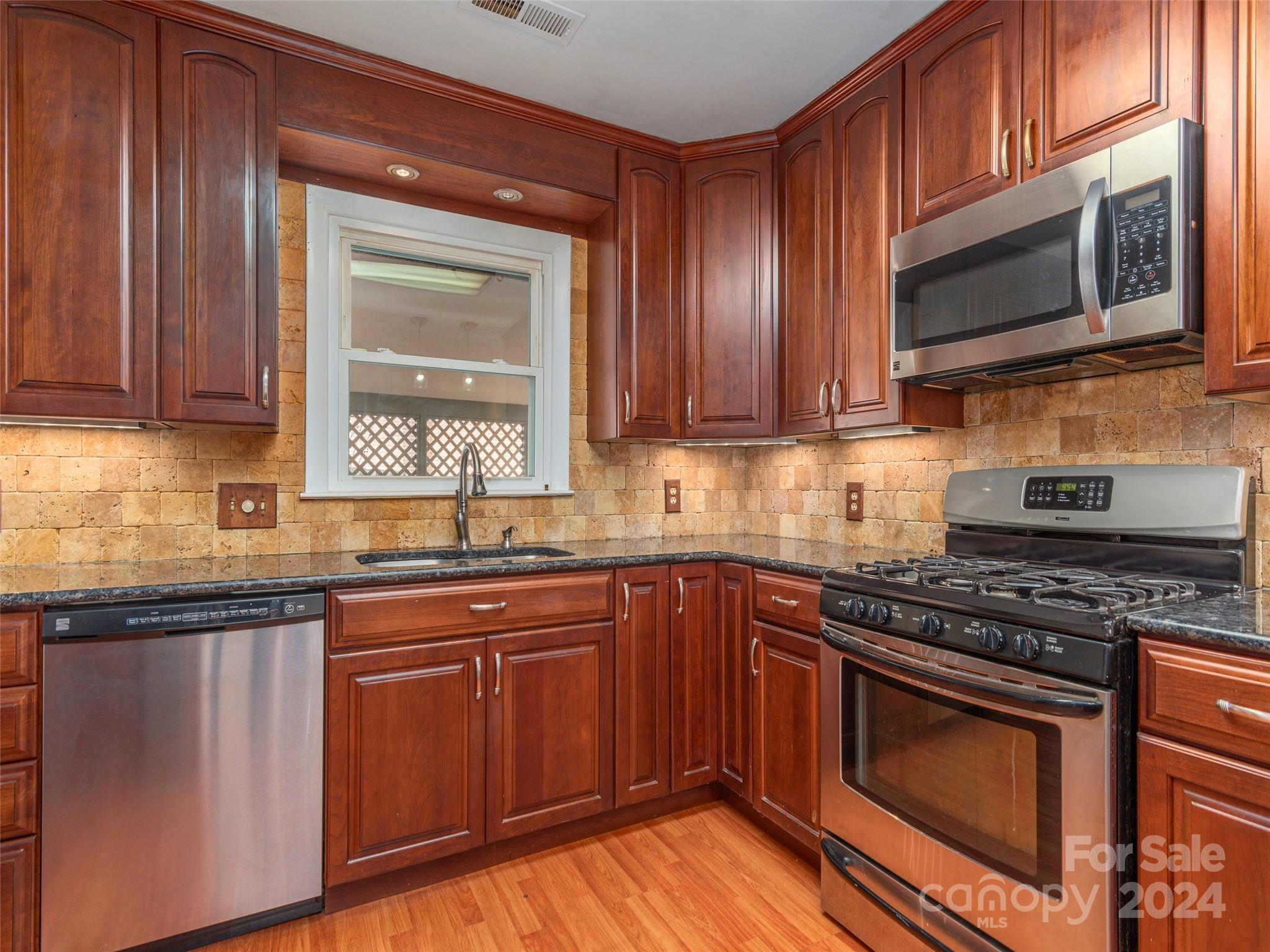 40 Wagon Road Asheville, NC 28805 - Photo 7 of 29 a kitchen with stainless steel appliances granite countertop wooden cabinets a stove top oven a sink and dishwasher