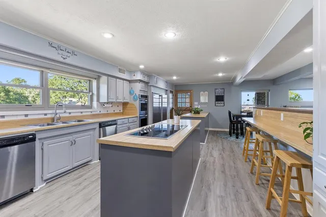 a kitchen with stainless steel appliances granite countertop lots of counter top space and wooden floor