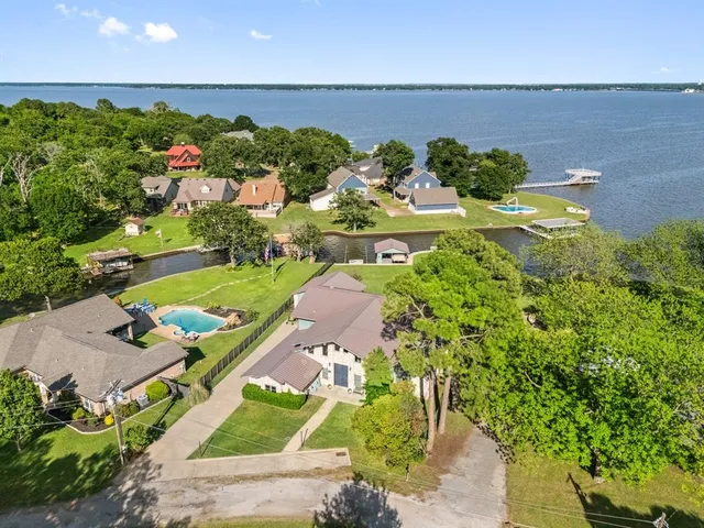 an aerial view of a house with a yard and lake view