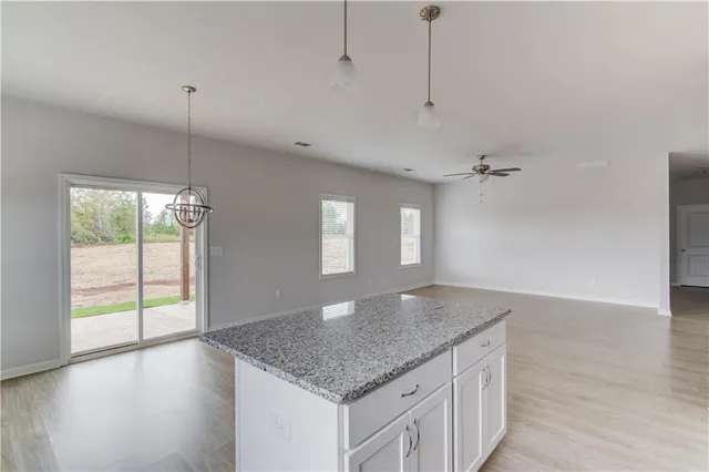 a kitchen with kitchen island a sink wooden floor and a large window