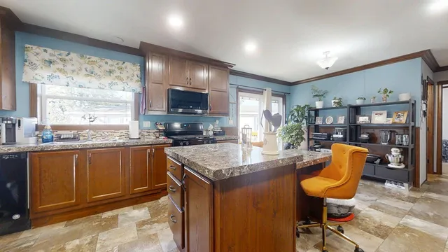 a kitchen with stainless steel appliances granite countertop a stove top oven a sink dishwasher a dining table and chairs with wooden floor