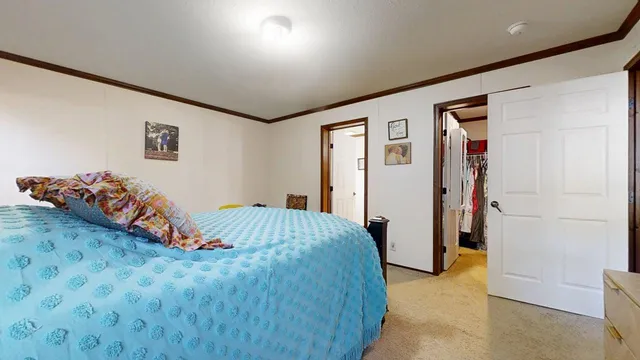 a bedroom with a bed and a painting on the wall