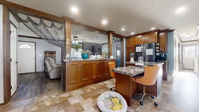 a kitchen with stainless steel appliances granite countertop a sink refrigerator and cabinets