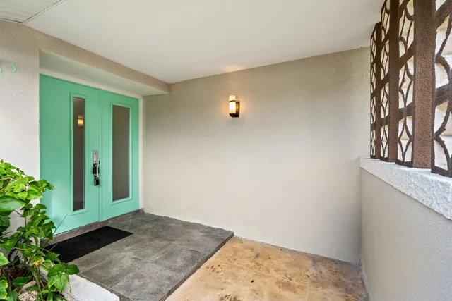 a view of a dining room and livingroom with furniture wooden floor a rug a flat screen tv a painting and a chandelier