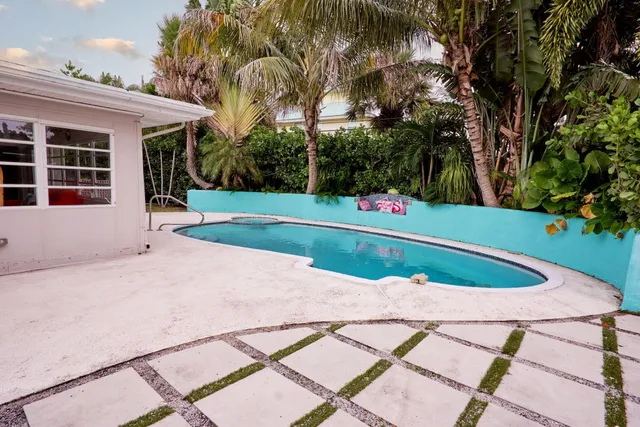 a view of house with a yard and potted plants