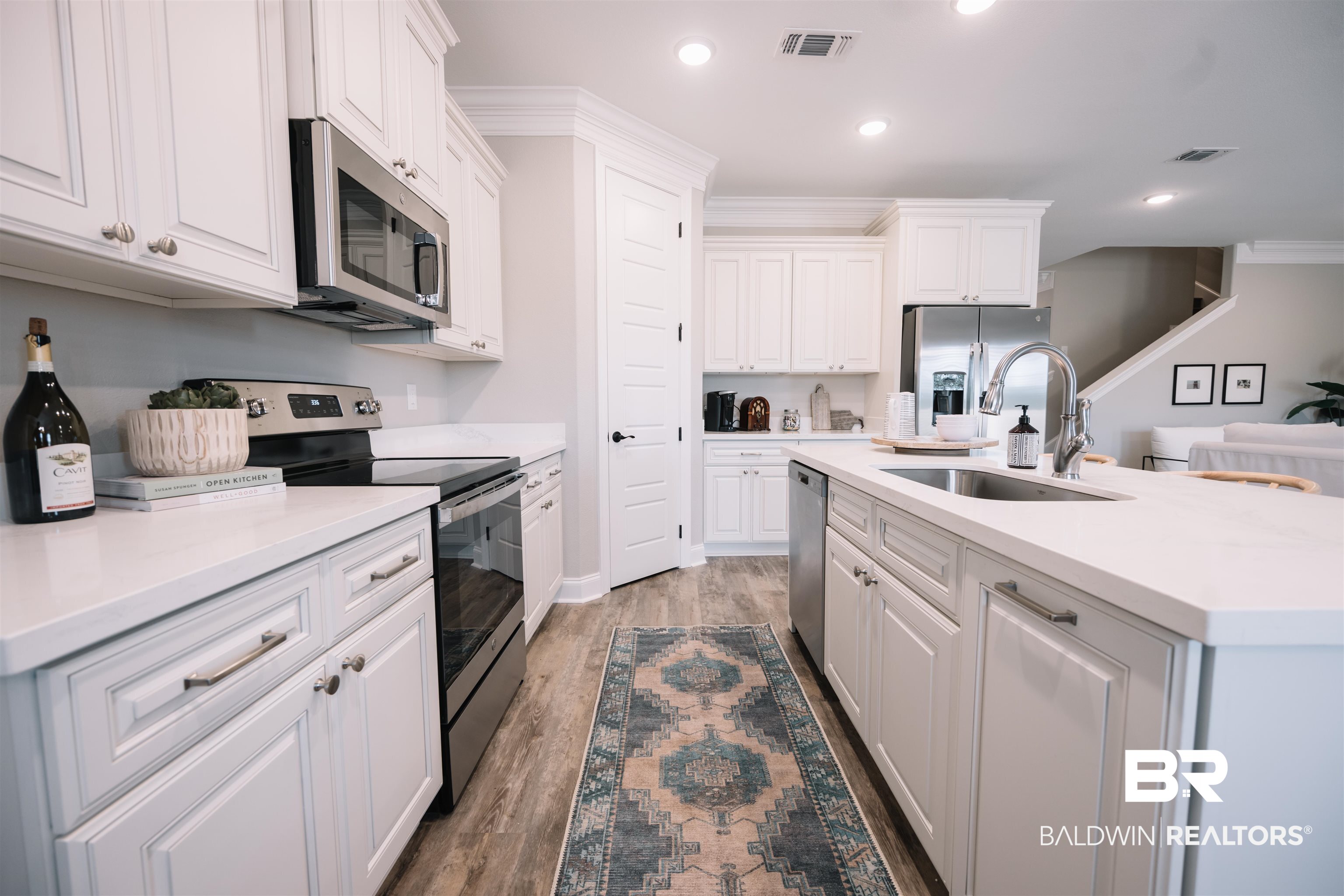 12894 Flanagan Street Elberta, AL 36530 - Photo 14 of 29 Kitchen featuring stainless steel appliances, an island with sink, sink, wood-type flooring, and white cabinets