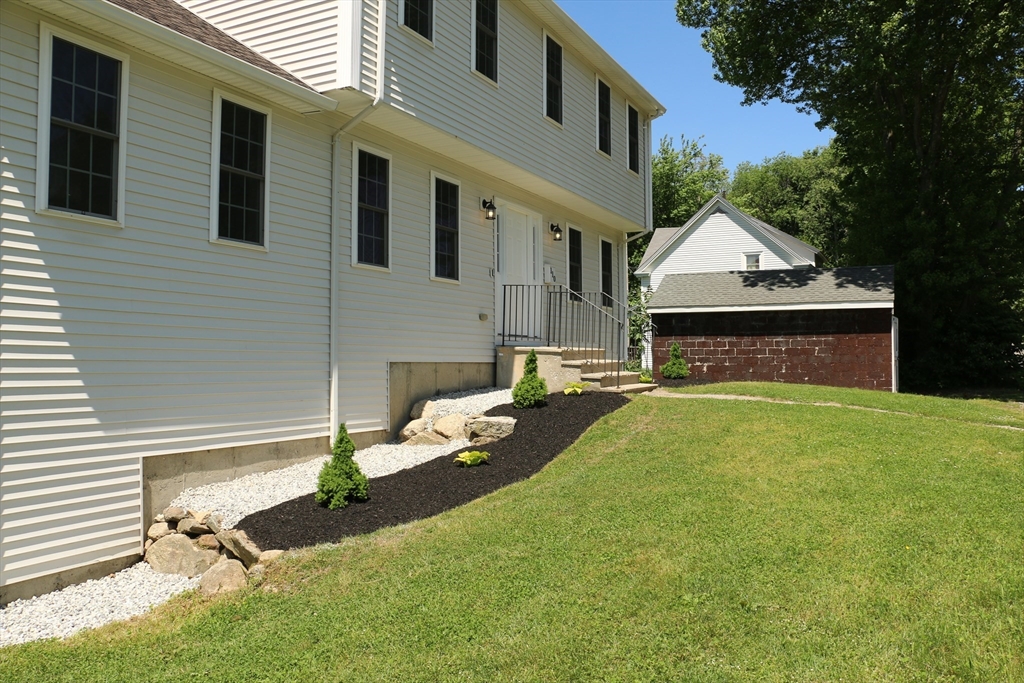 110 St Louis Street Worcester, MA 01607 - Photo 2 of 34 a front view of a house with a garden and a tree