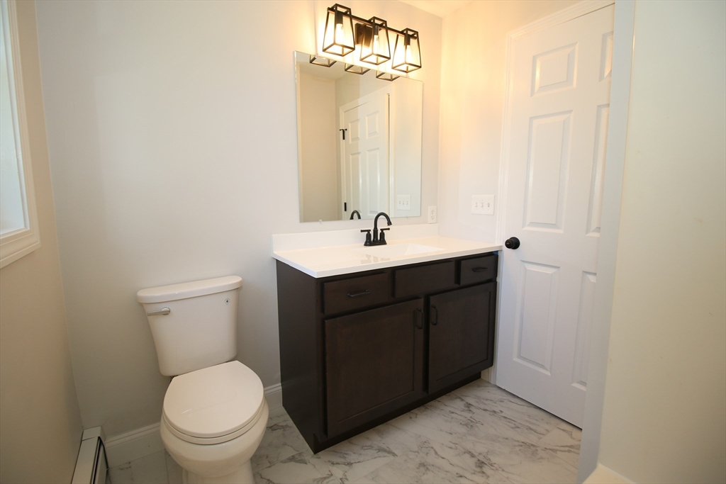 110 St Louis Street Worcester, MA 01607 - Photo 24 of 34 a bathroom with a sink vanity mirror and toilet