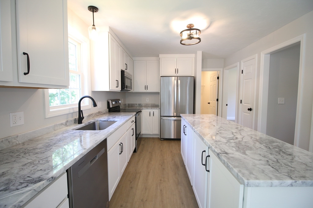 110 St Louis Street Worcester, MA 01607 - Photo 4 of 34 a large kitchen with stainless steel appliances granite countertop a sink refrigerator and cabinets