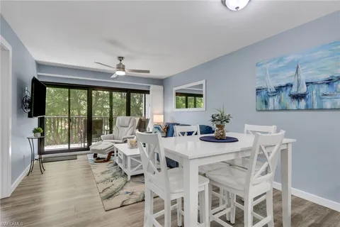 a view of a dining room with furniture large windows and wooden floor