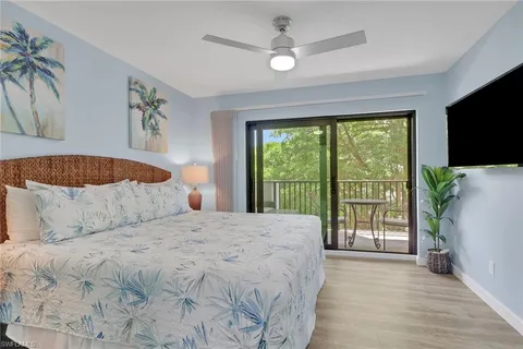 a large bedroom with a bed and a flat tv screen on dresser