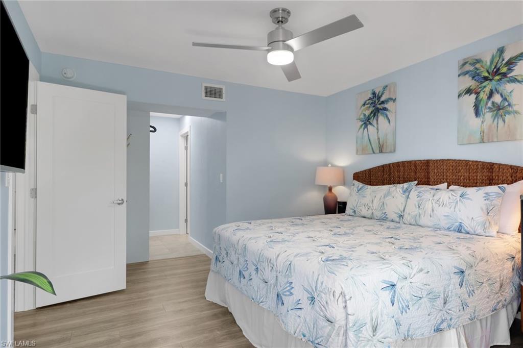 600 Neapolitan Way, Unit 357 Naples, FL 34103 - Photo 13 of 25 a bedroom with a large bed and a chandelier