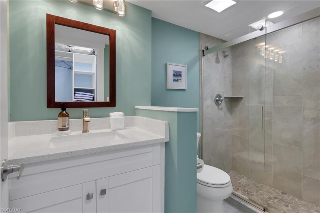 600 Neapolitan Way, Unit 357 Naples, FL 34103 - Photo 15 of 25 a bathroom with a sink a toilet and shower