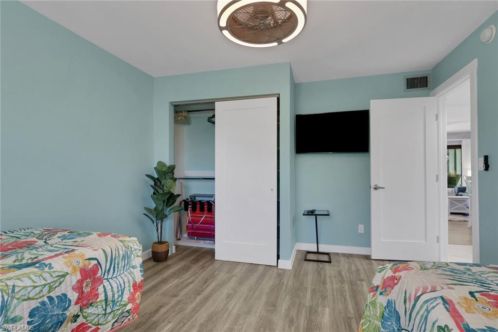 600 Neapolitan Way, Unit 357 Naples, FL 34103 - Photo 19 of 25 a bedroom with a bed and a chandelier