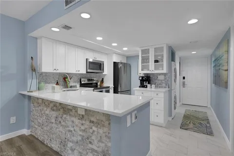 a large kitchen with kitchen island a sink stainless steel appliances and a counter top space