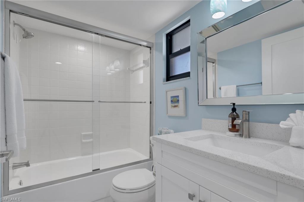 600 Neapolitan Way, Unit 357 Naples, FL 34103 - Photo 21 of 25 a bathroom with a bathtub shower sink vanity and toilet