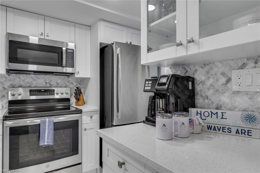 600 Neapolitan Way, Unit 357 Naples, FL 34103 - Photo 5 of 25 a kitchen with a refrigerator stove and microwave