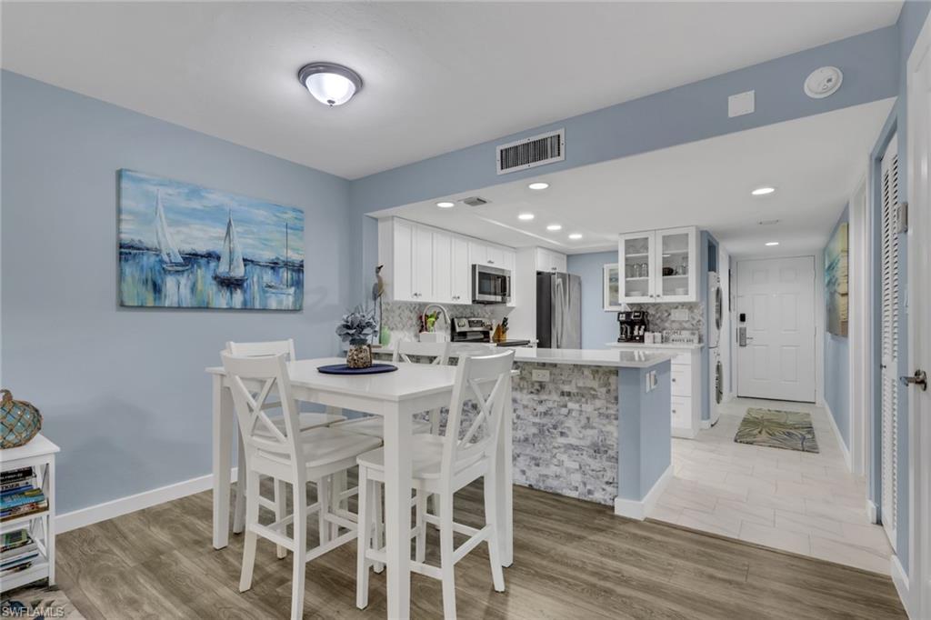 600 Neapolitan Way, Unit 357 Naples, FL 34103 - Photo 6 of 25 a view of a dining room with furniture and wooden floor