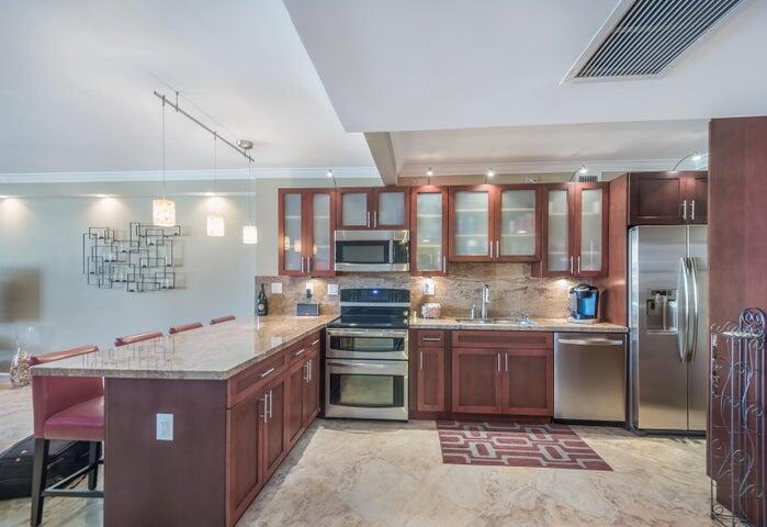 a kitchen with stainless steel appliances kitchen island granite countertop a stove a sink dishwasher and a refrigerator