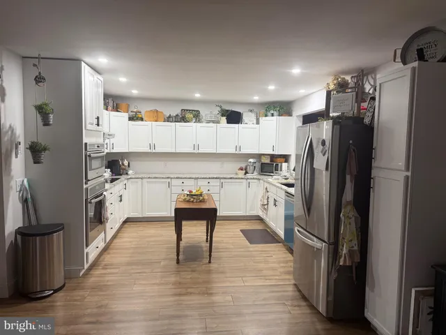 a kitchen with stainless steel appliances a refrigerator and a stove top oven