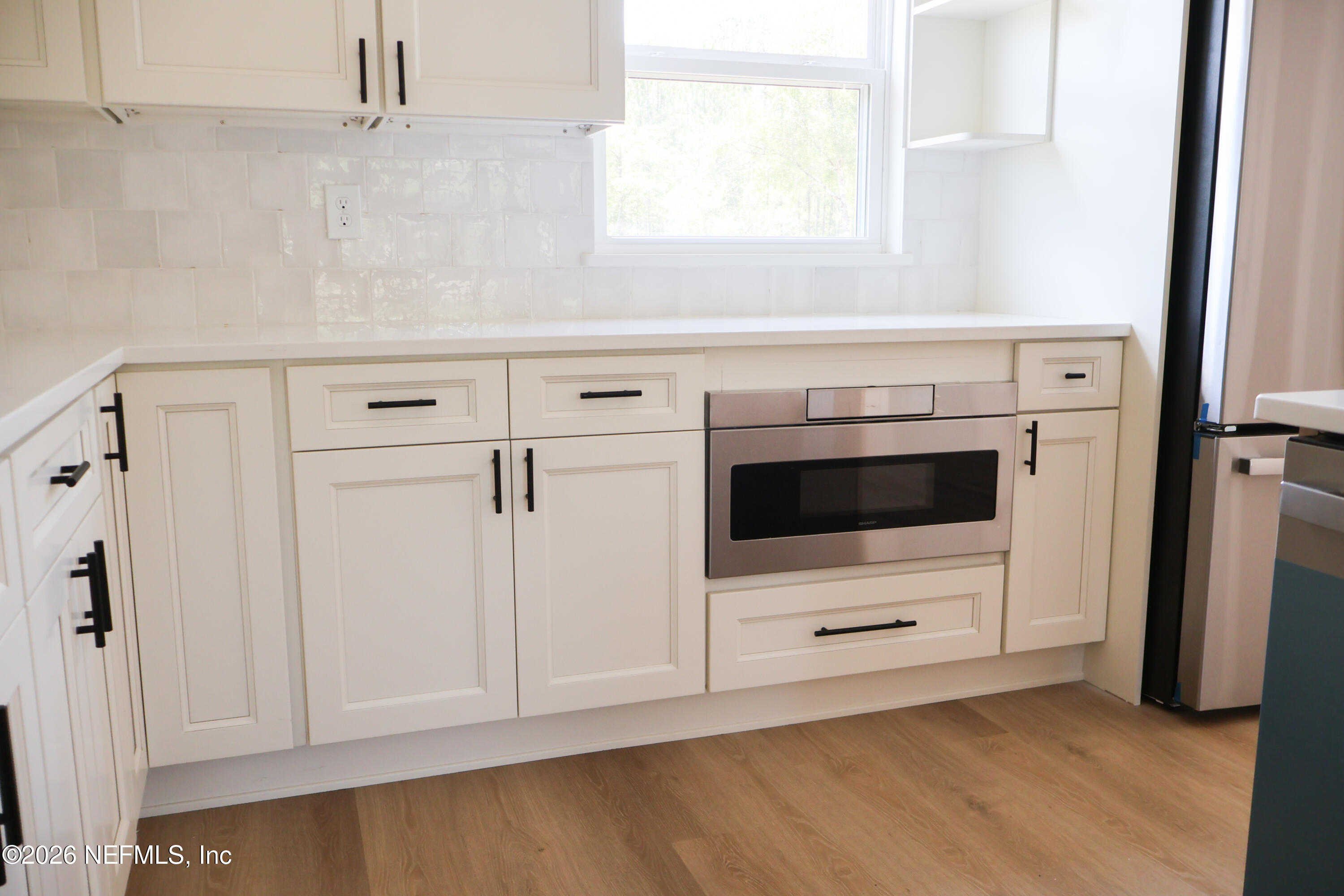 261121 Rowe Road Hilliard, FL 32046 - Photo 15 of 33 a kitchen with white cabinets and white appliances