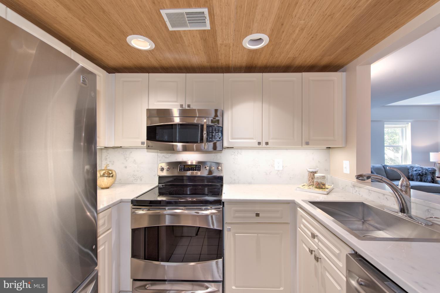 1727 R Street Northwest, Unit 202 Washington, DC 20009 - Photo 3 of 24 a kitchen with stainless steel appliances granite countertop a sink stove and microwave