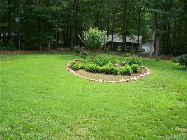 448 Lewis Road Clarksville, VA 23927 - Photo 12 of 12 This shows a planted area in the front yard as well as the nice lawn.
