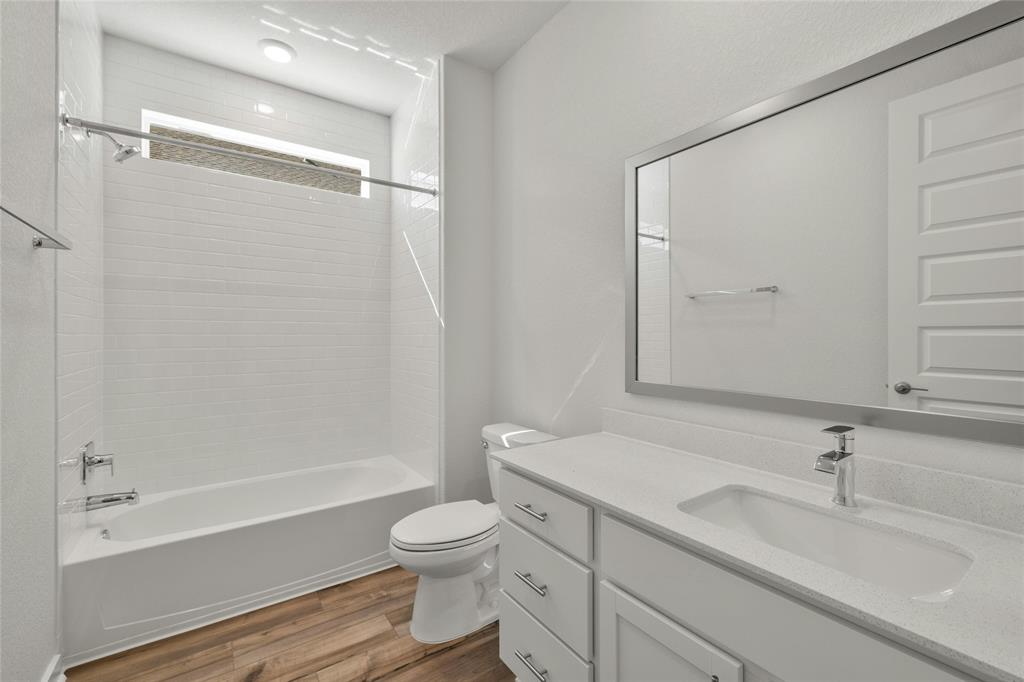 113 Shadow Oak Cove Georgetown, TX 78628 - Photo 18 of 40 A well-appointed bathroom features wood flooring and a modern vanity with integrated sink.