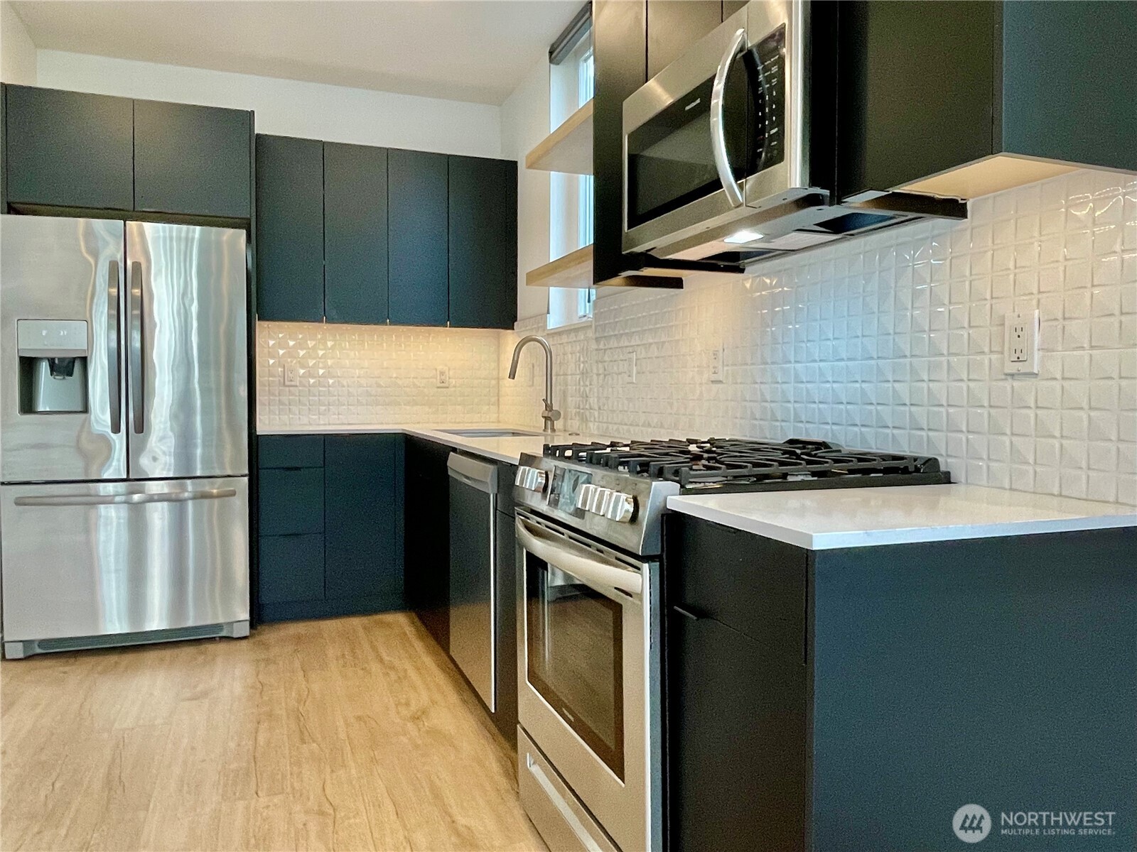 3307 Wetmore Avenue South, Unit A Seattle, WA 98144 - Photo 7 of 24 a kitchen with stainless steel appliances granite countertop a refrigerator and a stove