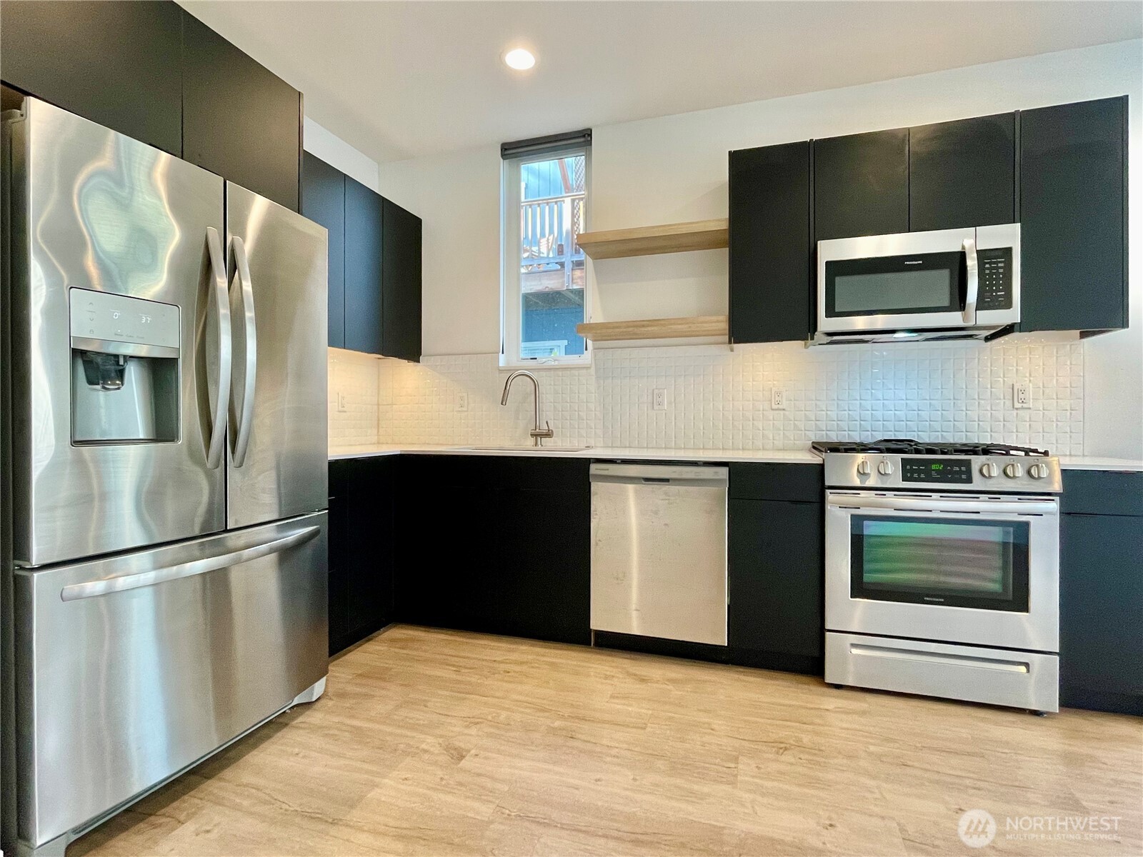 3307 Wetmore Avenue South, Unit A Seattle, WA 98144 - Photo 8 of 24 a kitchen with stainless steel appliances kitchen island granite countertop a refrigerator stove and microwave