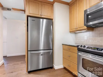 a kitchen with appliances a refrigerator and cabinets