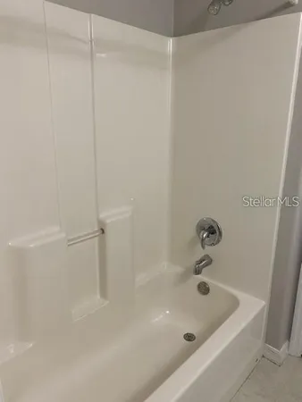 a bath tub sitting next to a white sink and vanity