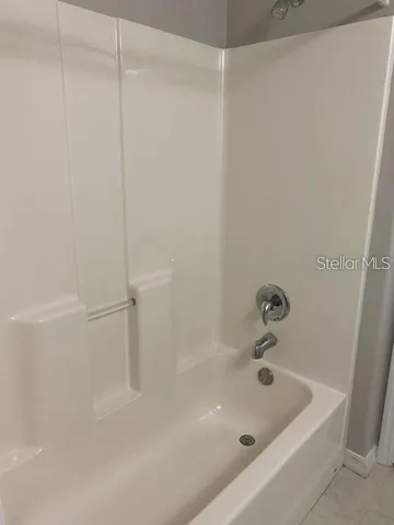 a bath tub sitting next to a white sink and vanity