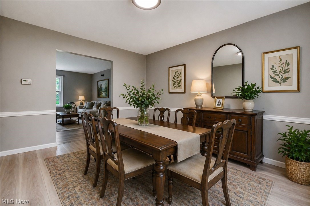 8242 Starburst Road Mentor, OH 44060 - Photo 6 of 37 Dining area featuring light wood-finish flooring, neutral wall paint, and white trim molding
