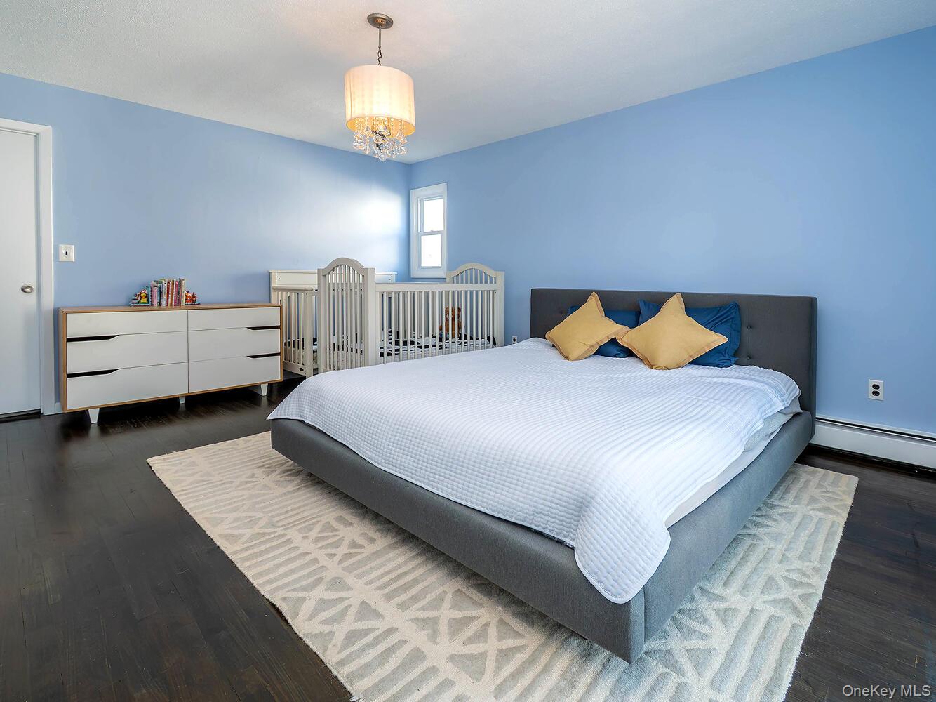 127 Cow Neck Road Port Washington, NY 11050 - Photo 16 of 31 a bedroom with a bed and wooden floor