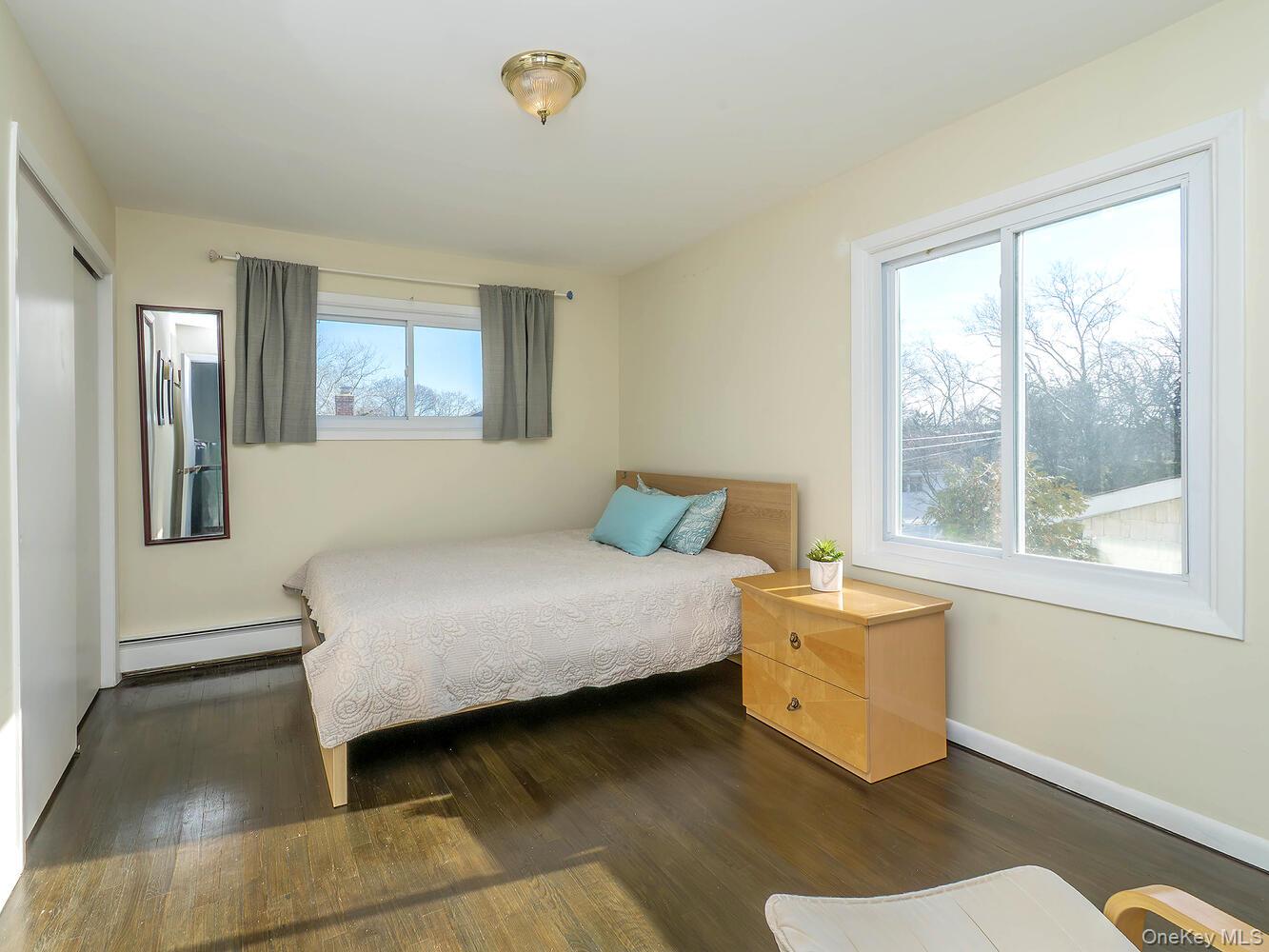 127 Cow Neck Road Port Washington, NY 11050 - Photo 21 of 31 a bedroom with a bed and wooden floor