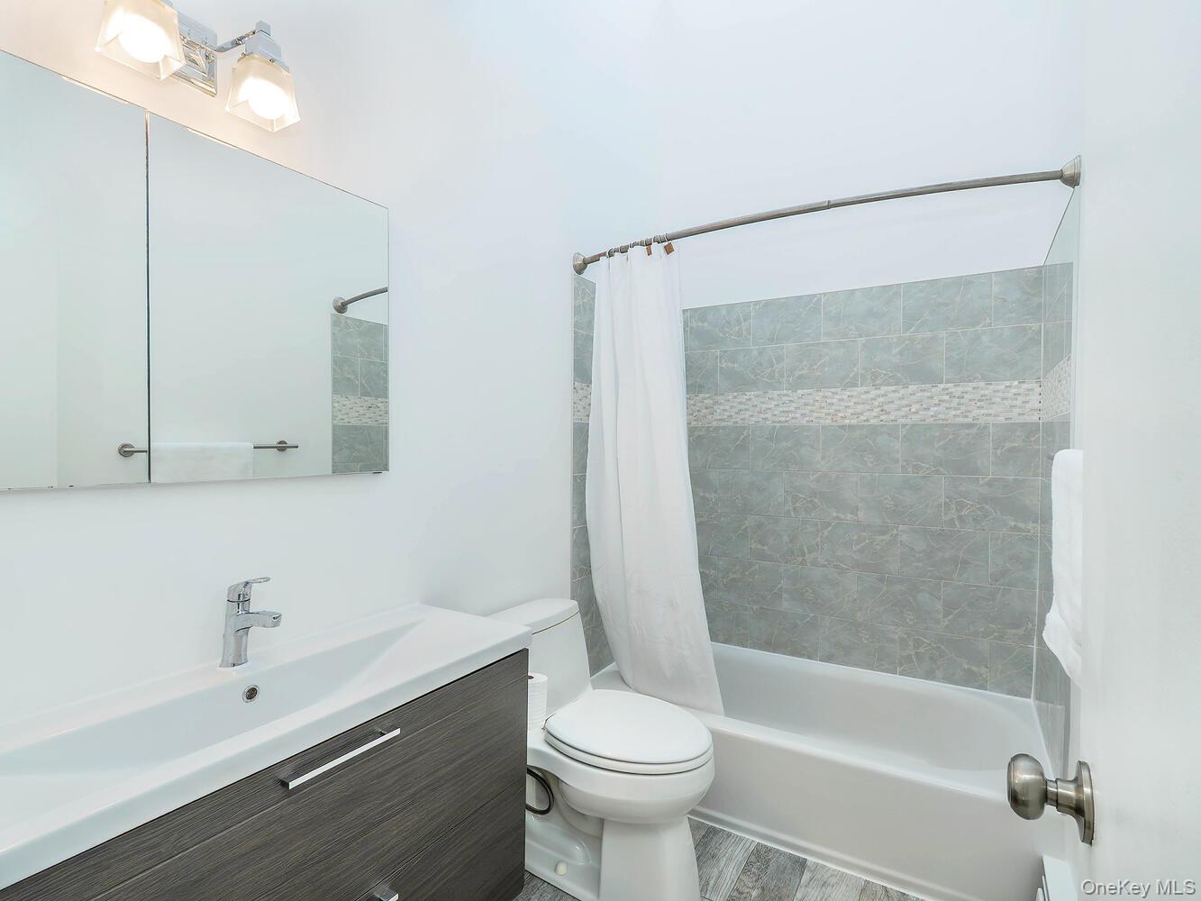 127 Cow Neck Road Port Washington, NY 11050 - Photo 22 of 31 a bathroom with a sink toilet and shower