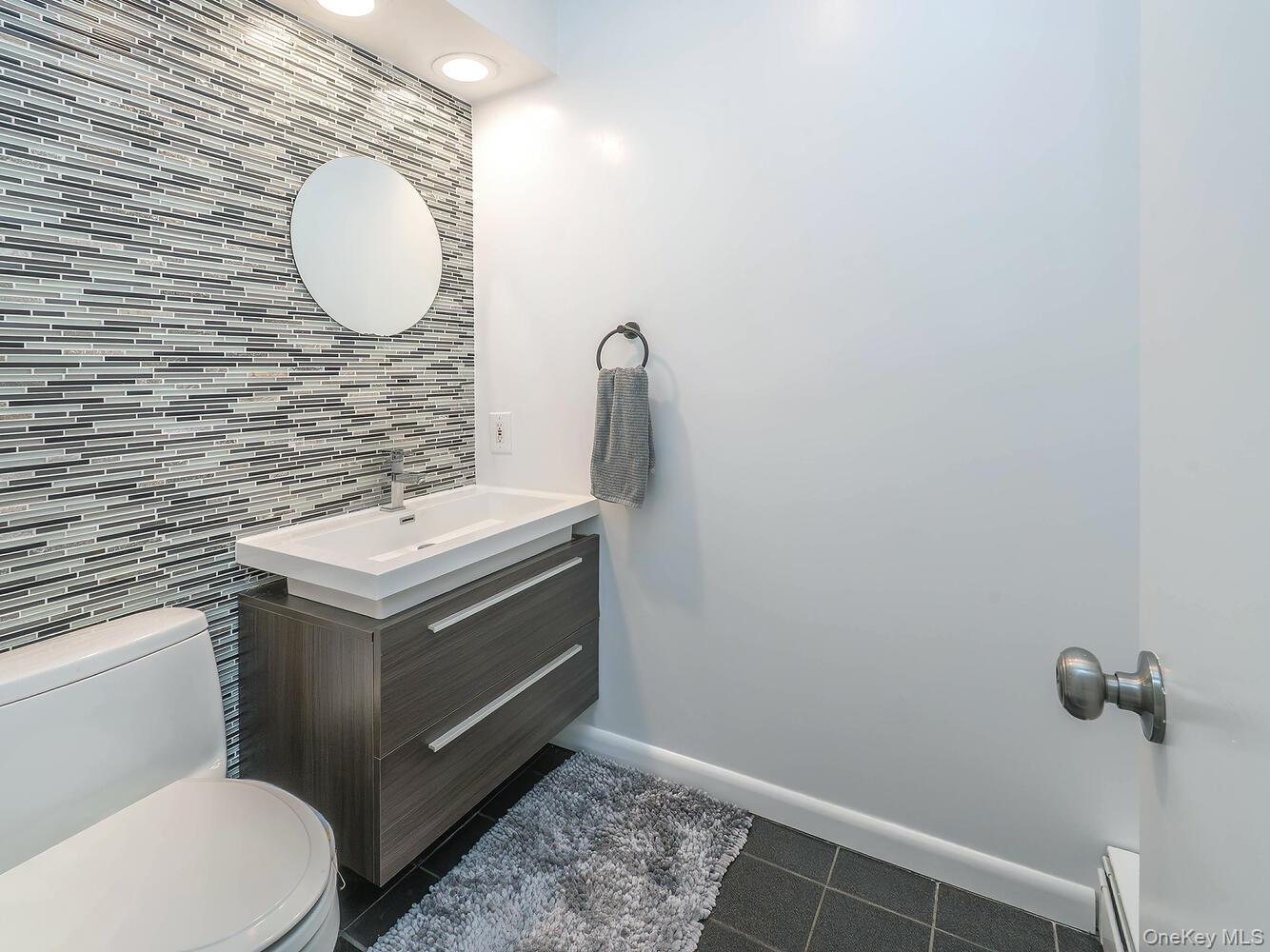 127 Cow Neck Road Port Washington, NY 11050 - Photo 23 of 31 a bathroom with a toilet a sink and mirror