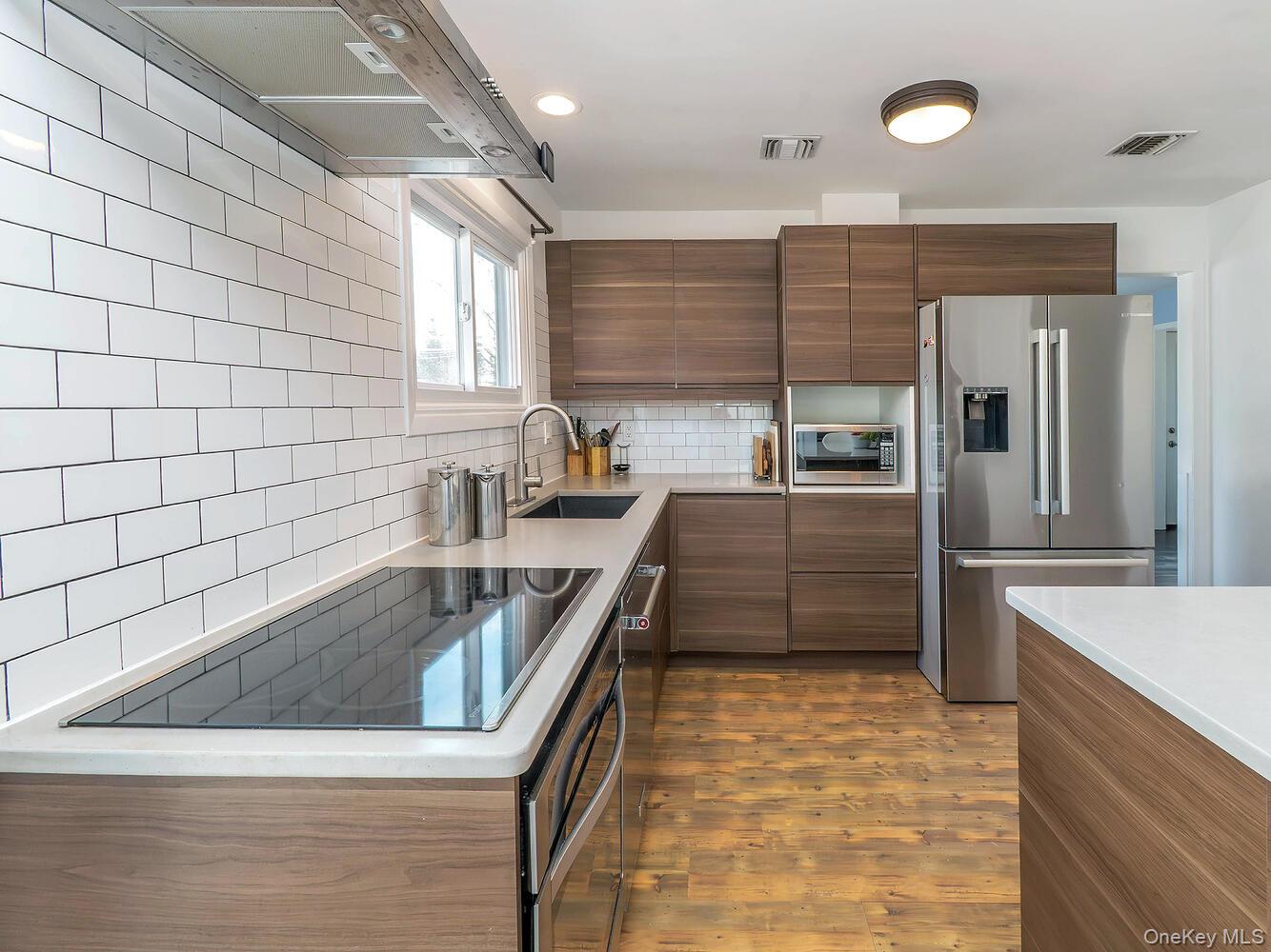127 Cow Neck Road Port Washington, NY 11050 - Photo 10 of 31 a kitchen with stainless steel appliances granite countertop a sink and a refrigerator