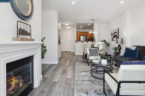 a living room with furniture a fireplace and a floor to ceiling window