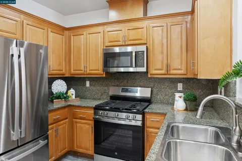 a kitchen with stainless steel appliances granite countertop a sink stove and microwave